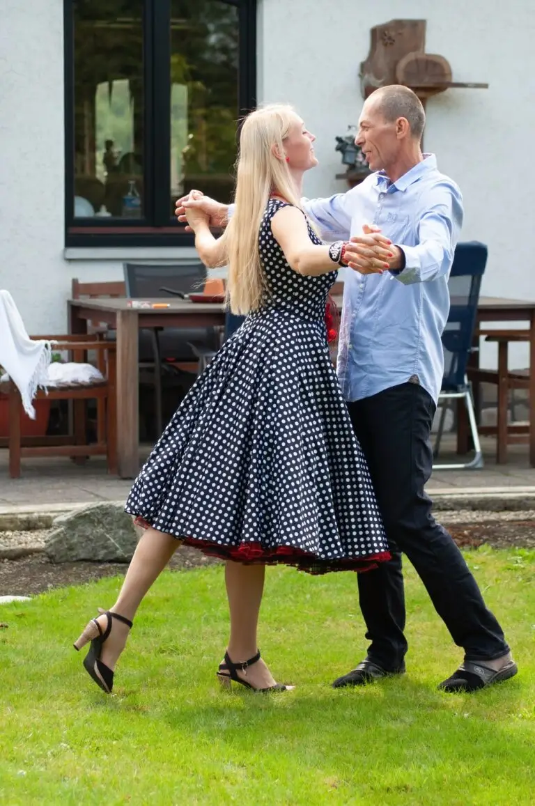 beautiful young couple of newlyweds dancing tango on the lawn in the garden
